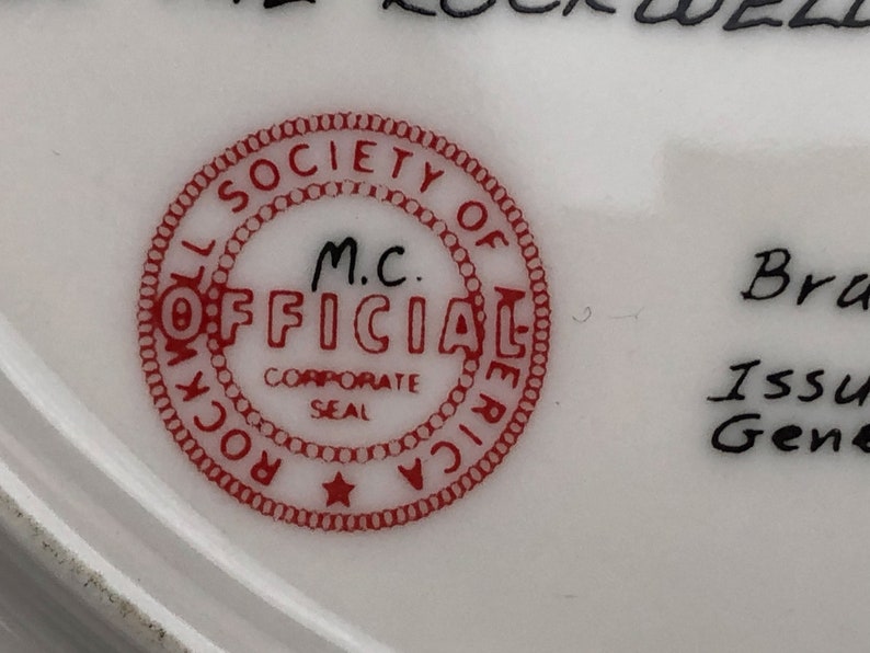 May include: Red and white circular seal with the text "Rockwell Society of America" and "M.C. Official Corporate Seal" inside. The seal has a star in the center.