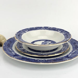 Peut inclure: Un ensemble de trois assiettes en porcelaine bleue et blanche avec une bordure dorée. Les assiettes présentent un motif chinois traditionnel avec un motif floral bleu et blanc.