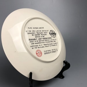 May include: White ceramic plate with a black and white image of a plate with the text "Plate Number 184/8 of the only limited edition of "Grandpa's Treasure Chest" by Norman Rockwell. Second in the Rockwell's Light Campaign Series. Made in an edition strictly limited to one hundred fifty firing days, and certified as a True Rockwell Classic by the Rockwell Society of America." The plate also has a red seal with the text "Brader Number 86/170-63 Issued with the cooperation of General Electric Company."