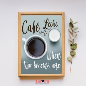 May include: A framed print with a blue background and white text that reads "Cafe Leche con When two become one". The print features a cup of coffee and a small glass of milk.