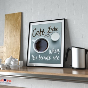May include: A framed print with a blue background and white text that reads "Cafe con Leche When two become one". The print features a cup of coffee and a small bowl of milk.