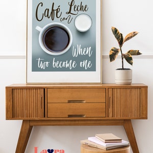 May include: A framed print with a blue background featuring a cup of coffee and a small pitcher of milk. The text reads "Cafe Leche con When two become one".