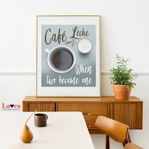 May include: A framed print with a blue background featuring a cup of coffee and a small cup of milk. The text reads "Cafe Leche con When two become one".