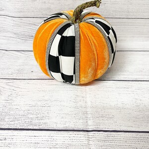 Pu&ograve; includere: Zucca di velluto arancione con nastro a quadri bianco e nero e strass.