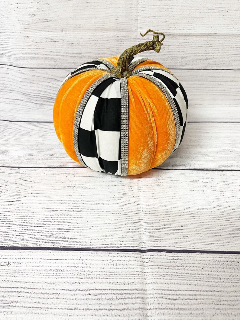 Pu&ograve; includere: Zucca di velluto arancione con nastro a quadri bianco e nero e strass.