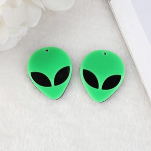 May include: Two green alien head shaped acrylic charms with black eyes.