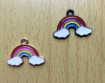 May include: Two rainbow charm pendants with white clouds. The rainbow is red, orange, yellow, green, blue, indigo, and violet. One charm is gold-toned and the other is black.