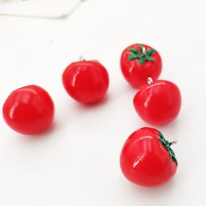 Può includere: Cinque ciondoli a forma di pomodoro rosso con foglie verdi e anelli di salto argentati. I ciondoli sono realizzati in pasta polimerica e sono perfetti per aggiungere un tocco di fantasia a gioielli o artigianato.