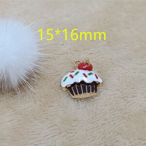 May include: Gold cupcake charm with white frosting and red and green sprinkles. The charm is 15mm by 16mm.