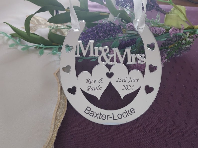 Puede incluir: Decoraci&oacute;n de boda de plata en forma de herradura con dos corazones entrelazados y el texto "Mr & Mrs", "Ray & Paula", "23rd June 2024" y "Baxter-Locke".