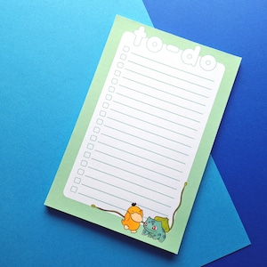 May include: A green to-do list notepad with a white border and the words "to-do" in white. The notepad has a line for each task and a check box next to each line. The notepad has a cartoon image of two Pokemon characters at the bottom.