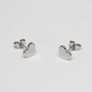 以下が含まれることがあります： ハート型のシルバーのスタッドピアスのペア