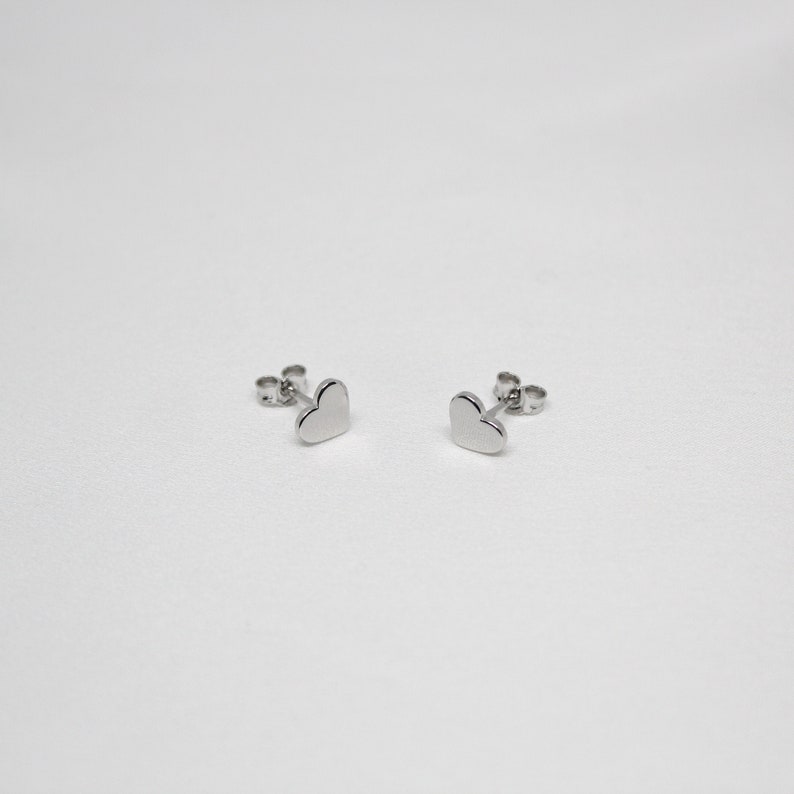 以下が含まれることがあります： ハート型のシルバーのスタッドピアスのペア