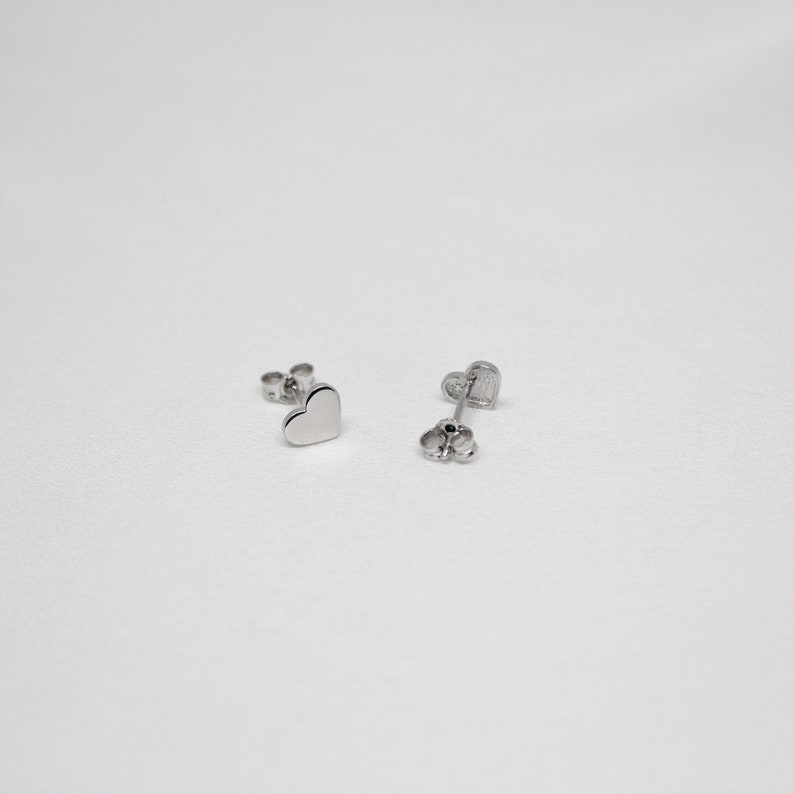 以下が含まれることがあります： ハート型のシルバーのスタッドピアスのペア
