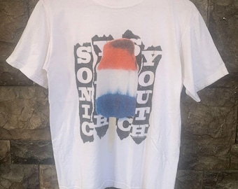 May include: White t-shirt with a red, white, and blue popsicle graphic and the text "Sonic Youth"