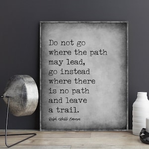 Op de afbeelding: Een inspirerend citaat van Ralph Waldo Emerson in zwart-wit op een gestructureerde grijze achtergrond. Het citaat luidt: "Ga niet waar het pad leidt, ga in plaats daarvan waar geen pad is en laat een spoor achter."