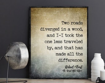 May include: A vintage-style print with a quote from Robert Frost's poem "The Road Not Taken." The quote reads: "Two roads diverged in a wood, and I-I took the one less traveled by, and that has made all the difference."