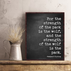 May include: Black and white typography quote on a chalkboard background with a wooden frame. The quote reads "For the strength of the pack is the wolf, and the strength of the wolf is the pack." -Rudyard Kipling
