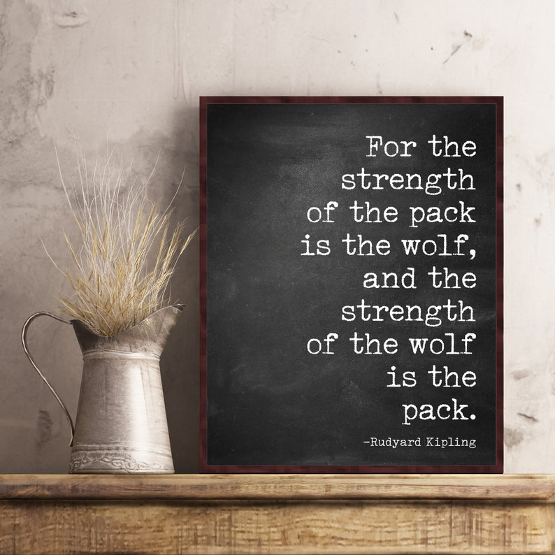May include: Black and white typography quote on a chalkboard background with a wooden frame. The quote reads "For the strength of the pack is the wolf, and the strength of the wolf is the pack." -Rudyard Kipling