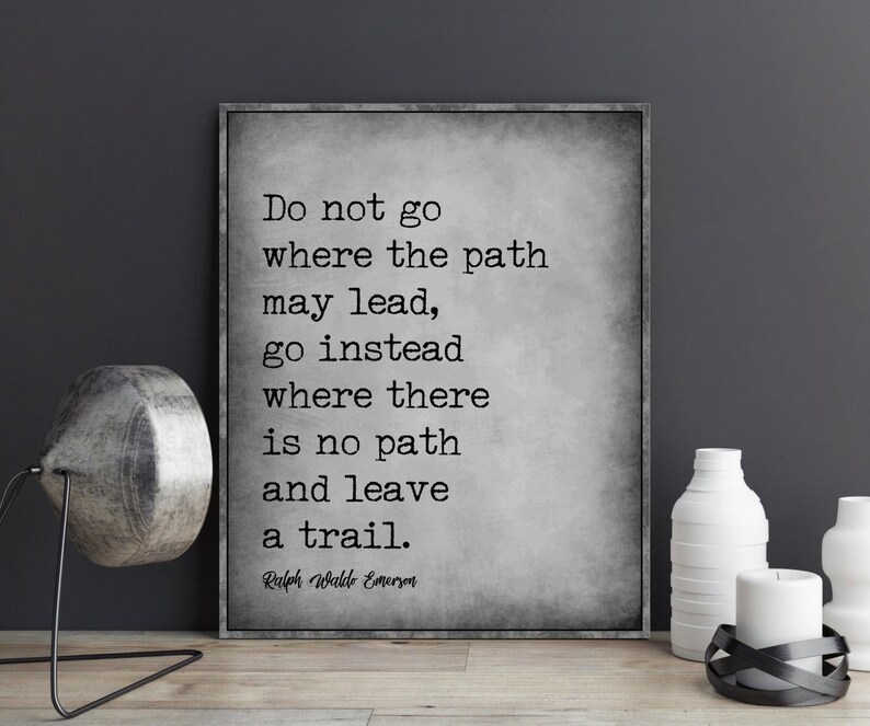 Op de afbeelding: Een inspirerend citaat van Ralph Waldo Emerson in zwart-wit op een gestructureerde grijze achtergrond. Het citaat luidt: "Ga niet waar het pad leidt, ga in plaats daarvan waar geen pad is en laat een spoor achter."