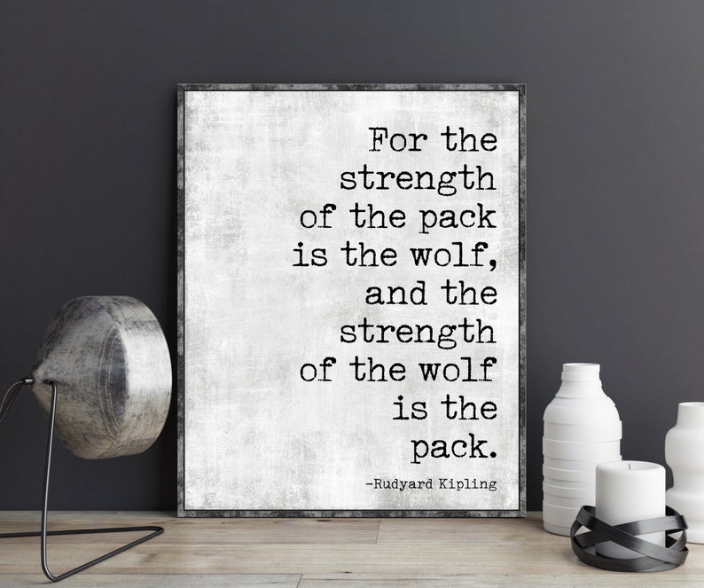 May include: Black and white typography print with a quote by Rudyard Kipling: "For the strength of the pack is the wolf, and the strength of the wolf is the pack."