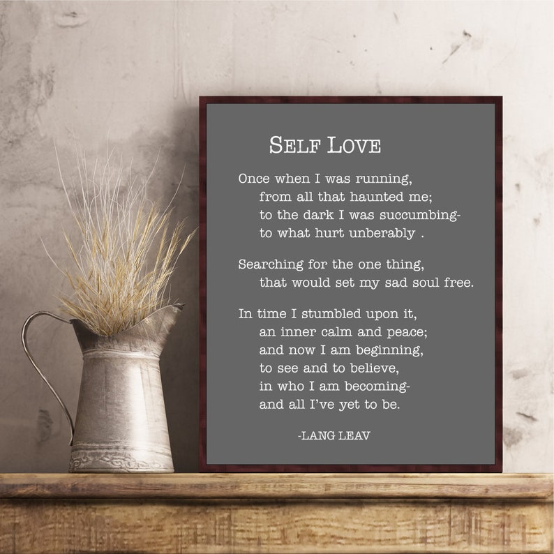 May include: A framed print with a gray background and white text. The text is a poem titled "Self Love" by Lang Leav. The poem is about finding inner peace and self-acceptance.