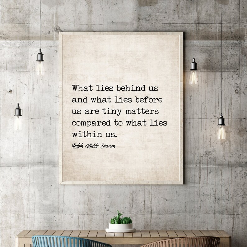 May include: A framed print with the quote "What lies behind us and what lies before us are tiny matters compared to what lies within us." by Ralph Waldo Emerson. The print is displayed on a concrete wall with hanging light fixtures.