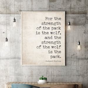 May include: A black and white typography print with a quote by Rudyard Kipling: "For the strength of the pack is the wolf, and the strength of the wolf is the pack."