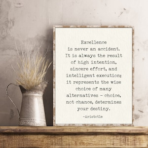 May include: A framed print with a white background and black text. The text reads: "Excellence is never an accident. It is always the result of high intention, sincere effort, and intelligent execution; it represents the wise choice of many alternatives - choice, not chance, determines your destiny. -Aristotle"