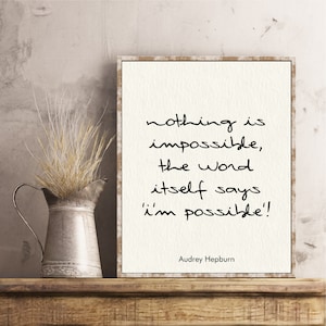 May include: A framed print with a white background and black text. The quote reads "nothing is impossible, the word itself says 'i'm possible!'". The quote is attributed to Audrey Hepburn.