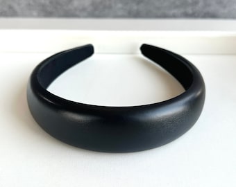 Könnte beinhalten: Ein schwarzes gepolstertes Haarband.