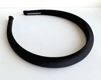 Könnte beinhalten: Ein schwarzes Stoffhaarband mit dem Aufdruck "HANDMADE".