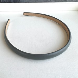 Peut inclure: Un serre-tête gris foncé avec une finition lisse et mate. L'intérieur est de couleur marron clair. Le serre-tête est un accessoire simple et élégant.