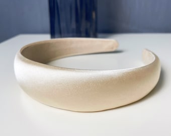 May include: A wide, cream-colored satin headband.