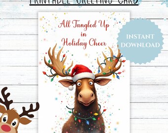 May include: A printable greeting card featuring a whimsical moose wearing a Santa hat and wrapped in Christmas lights. The card reads "All Tangled Up in Holiday Cheer" with an "Instant Download" label. The design has a watercolor effect.