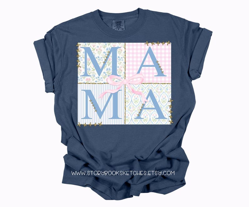 May include: A navy blue t-shirt with a patchwork design featuring the word "MAMA" in blue letters with a pink bow. The design is reminiscent of a quilt.