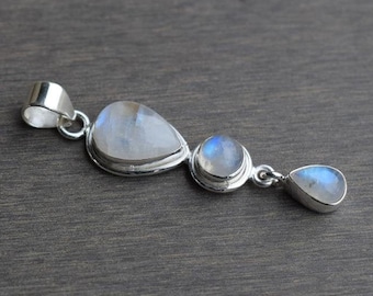May include: A silver pendant with three teardrop-shaped moonstone gems. The pendant is made of sterling silver and features a polished finish.