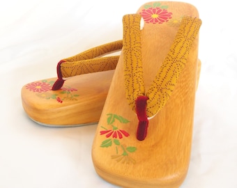 Elegant wooden geta- ocher and red traditional Japanese shoes with floral pattern