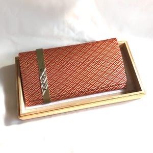Cartera japonesa fina con diseño geométrico dorado y naranja