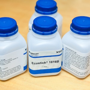 May include: Four white plastic bottles with blue screw-on caps. The bottles are labeled "Ecostick 1816B" and contain 8 oz of adhesive. The labels also include instructions for use and other product information.