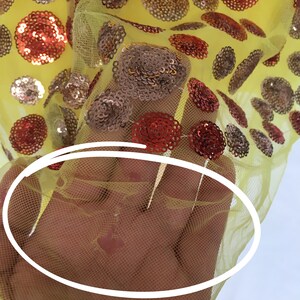 May include: Yellow mesh fabric with red and gold sequins in a polka dot pattern.