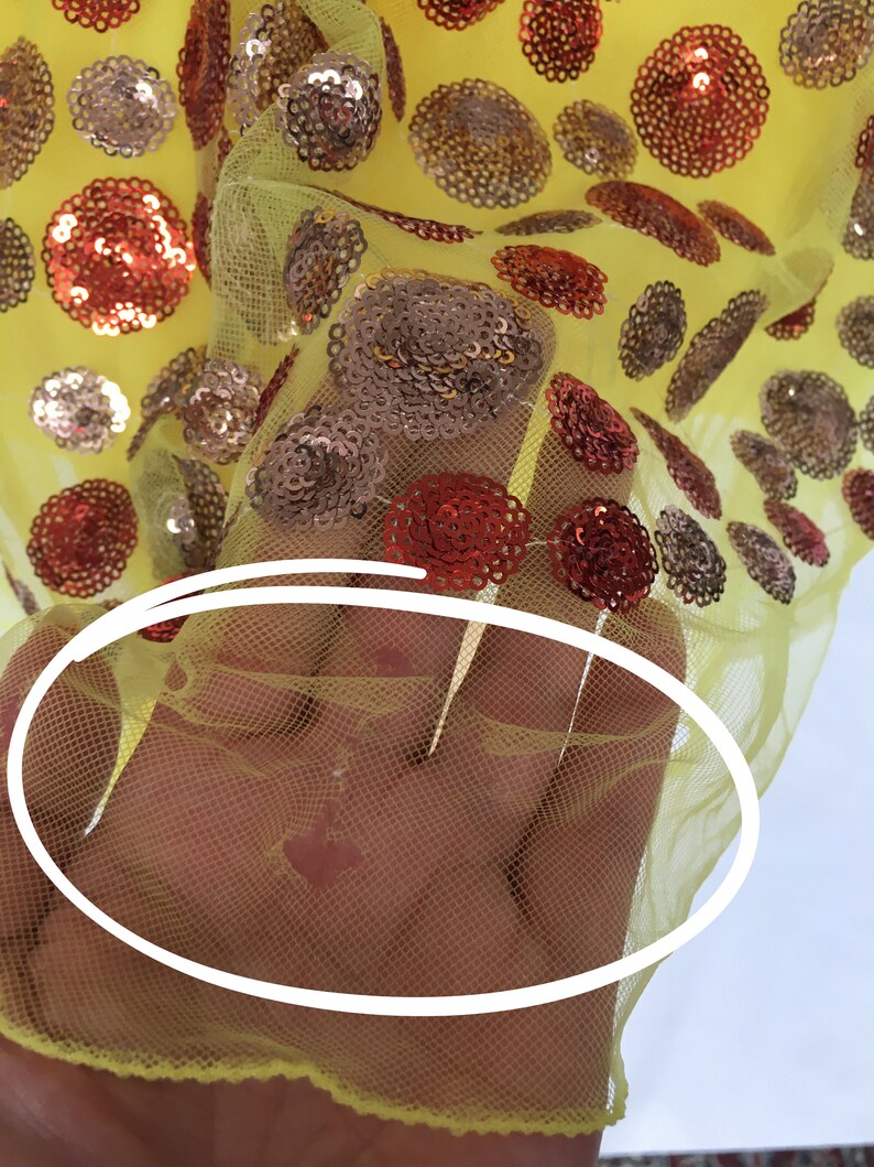 May include: Yellow mesh fabric with red and gold sequins in a polka dot pattern.