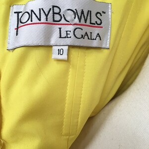 May include: A yellow fabric label with the text "TONY BOWLS&trade; LE GALA" and a size tag that says "10".