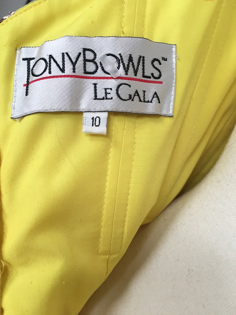 May include: A yellow fabric label with the text "TONY BOWLS&trade; LE GALA" and a size tag that says "10".