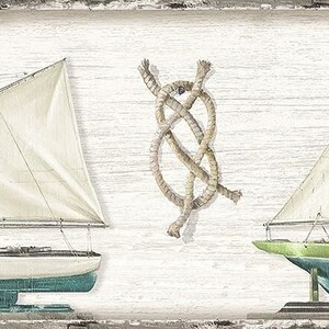 May include: Two white sailboats with blue hulls and a rope knot on a white wood background.