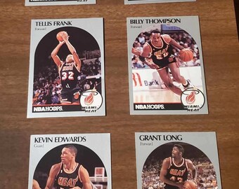 Könnte beinhalten: Ein Set mit 6 Sammelkarten, die die Basketballmannschaft Miami Heat zeigen. Die Karten sind silberfarben mit weißem Rand und zeigen ein Foto jedes Spielers in seiner Uniform. Die Karten enthalten den Namen des Spielers, seine Position und das Teamlogo.