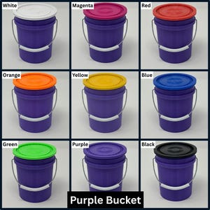 K&ouml;nnte beinhalten: Neun lilafarbene Eimer mit Deckeln in verschiedenen Farben: Wei&szlig;, Magenta, Rot, Orange, Gelb, Blau, Gr&uuml;n, Lila und Schwarz. Jeder Eimer hat einen silbernen Griff und ein wei&szlig;es Band. Der Text "Purple Bucket" steht unten.