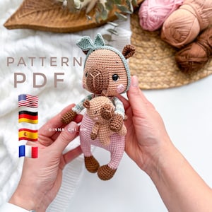 Peut inclure: Patron de crochet PDF pour un lama amigurumi brun et rose tenant un plus petit lama amigurumi brun et rose. Le patron comprend des instructions pour la réalisation des deux lamas. Le patron est disponible en anglais, allemand, espagnol et français.