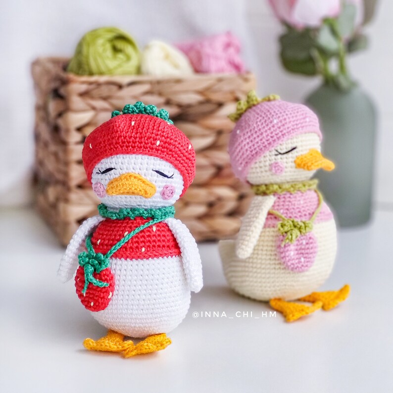 Peut inclure: Deux figurines de canard faites &agrave; la main au crochet. L'un porte un chapeau, une &eacute;charpe et un sac fraise rouges. L'autre porte un chapeau, une &eacute;charpe et un sac roses. Les deux canards ont des pieds et des becs jaunes et les yeux ferm&eacute;s.