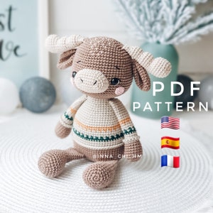 May include: Crochet amigurumi pattern for a brown and white bull wearing a green and orange sweater. The pattern is available in English, Spanish, and French. PDF pattern.